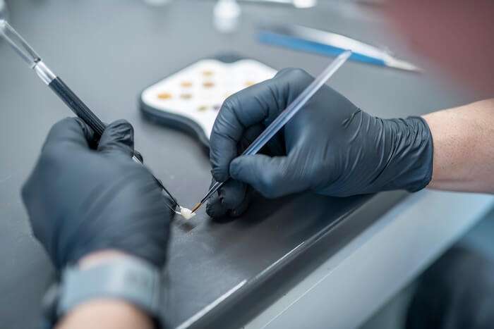 zahntechniker-muenchen-modell-zahnreihe-dentallabor-citadelle-handschuhe-zahn-charakterisieren